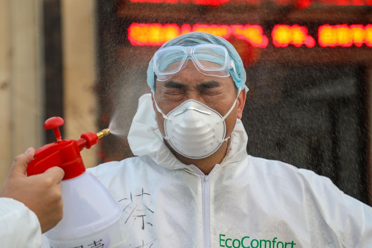 A doctor is sprayed with a disinfectant by his colleague at a quarantine zone in Wuhan, the epicenter of the new coronavirus outbreak, in China's central Hubei Province, on Feb. 3, 2020. (STR/AFP via Getty Images)