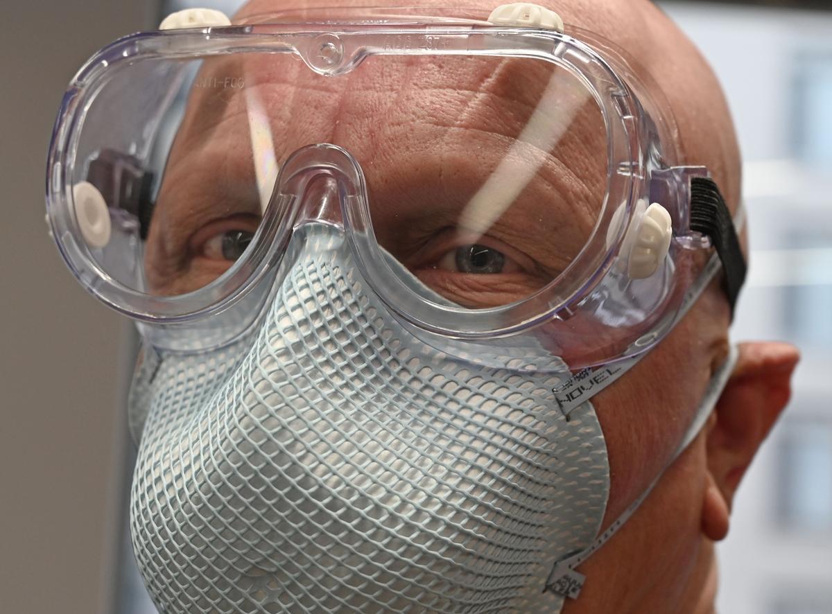 A man displays a protective N95 face mask and goggles at an office in Washington on Feb. 26, 2020. (Eva Hambach/AFP via Getty Images)