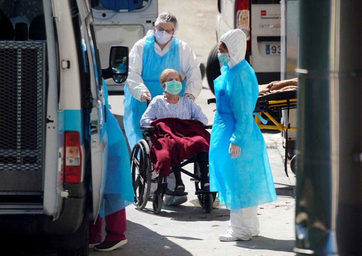 Ambulance workers push a wheelchair with a patient at a nursing home during the CCP virus outbreak in Leganes Madrid, near Madrid, on April 2, 2020. (Juan Medina/Reuters)