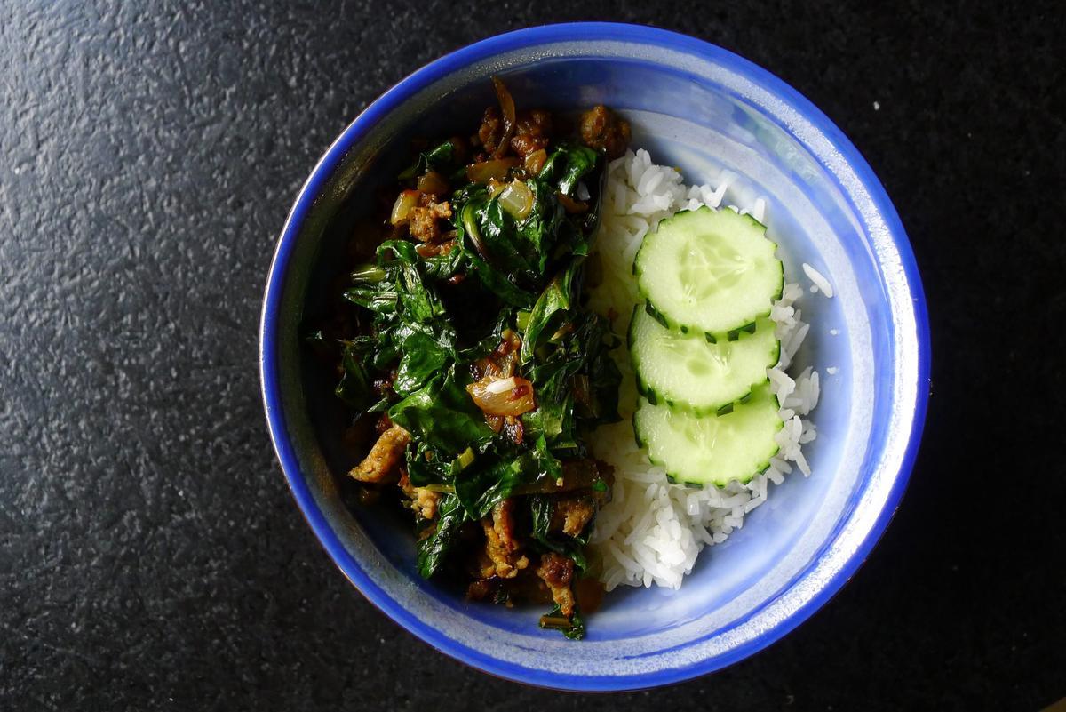 Beet greens are cooked with sausage, onions, and soy sauce, then served over rice. (Ari LeVaux)