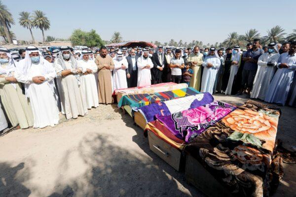 Mourners pray near coffins containing the dead bodies of victims, who were killed in rocket attacks, in Abu Ghraib district, on the outskirts of Baghdad, Iraq, on Sept. 29, 2020. (Khalid al-Mousily/Reuters)