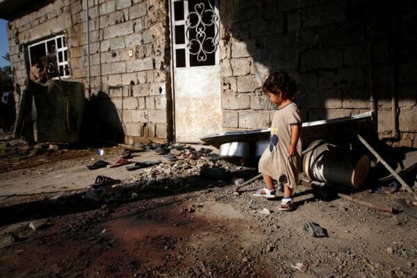 A girl is seen outside a house damaged by a rocket attack in the Abu Ghraib district, on the outskirts of Baghdad, Iraq, on Sept. 29, 2020. (Saba Kareem/Reuters)