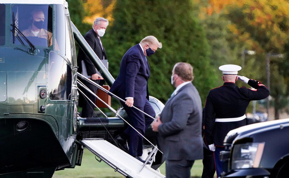 President Donald Trump disembarks from the Marine One helicopter followed by White House chief of staff Mark Meadows as he arrives at Walter Reed National Military Medical Center, in Bethesda, Md., on Oct. 2, 2020. (Joshua Roberts/Reuters)