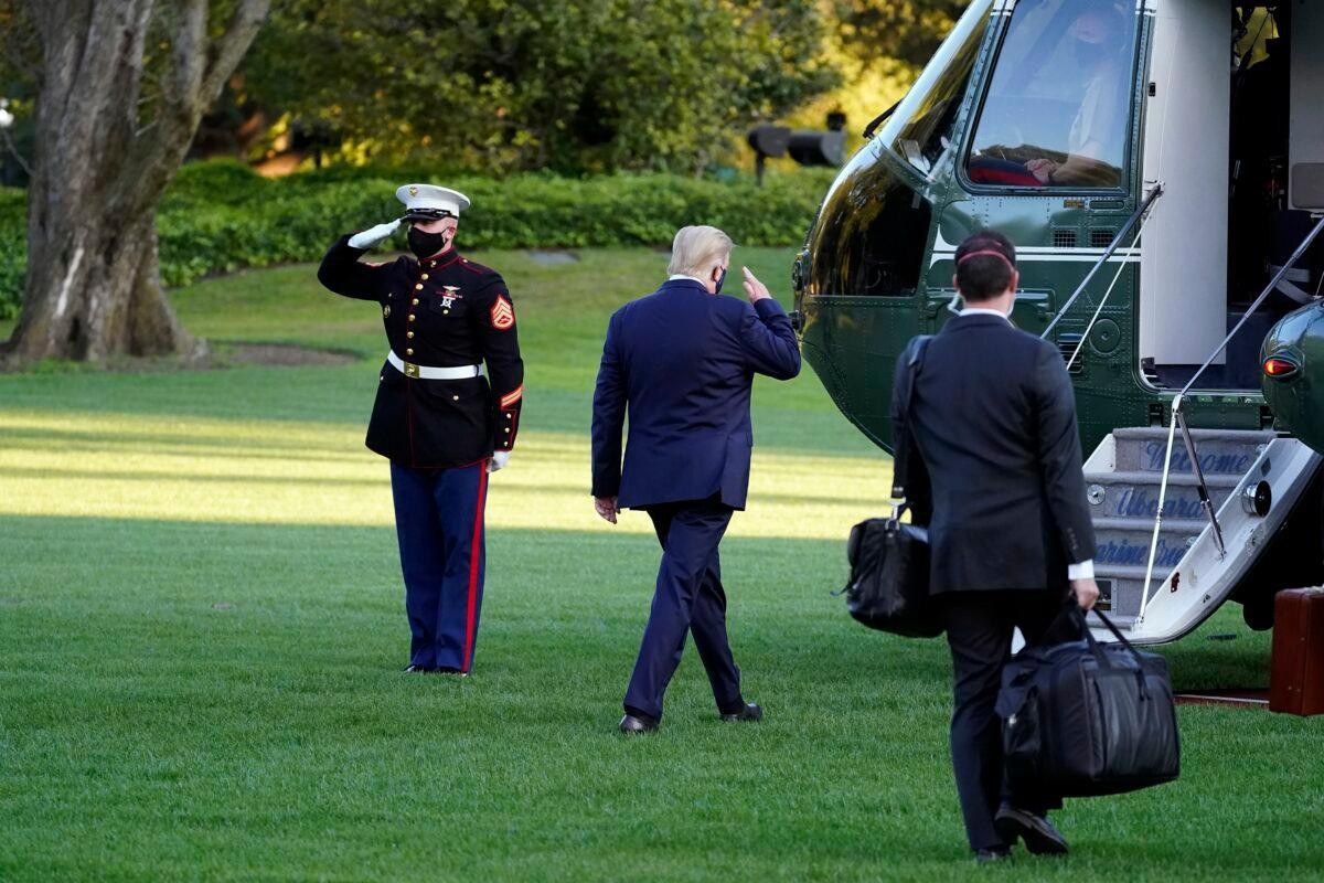 President Donald Trump salutes as he boards Marine One outside the White House to go to Walter Reed National Military Medical Center after he tested positive for COVID-19, in Washington on Oct. 2, 2020. (Alex Brandon/AP Photo)