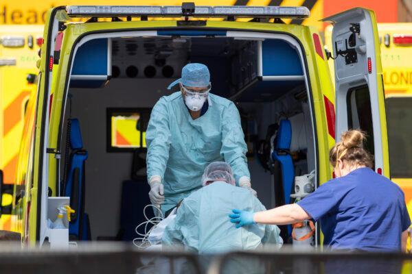 NHS workers in PPE take a patient with an unknown condition from an ambulance at St Thomas' Hospital in London, on April 10, 2020. (Justin Setterfield/Getty Images)