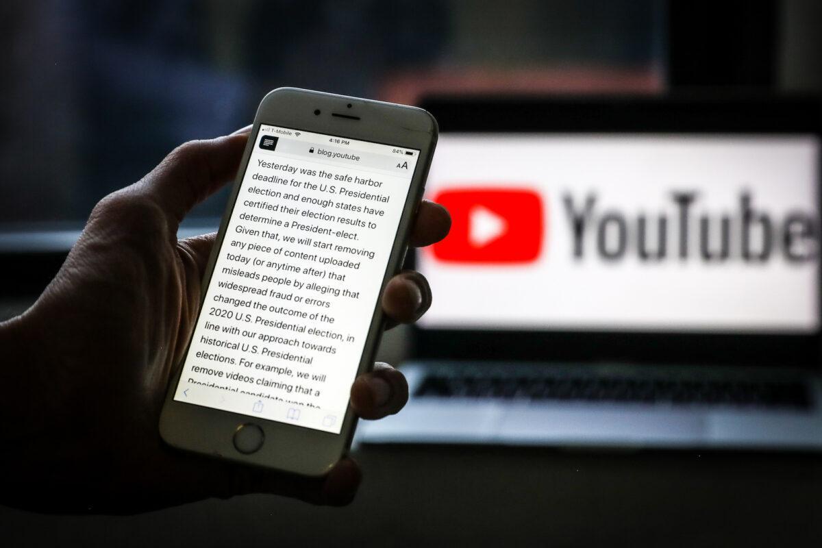 A YouTube announcement that the company will immediately start removing content alleging "widespread fraud or errors" in this year's presidential election is displayed on a phone on Dec. 9, 2020. (Samira Bouaou/The Epoch Times)