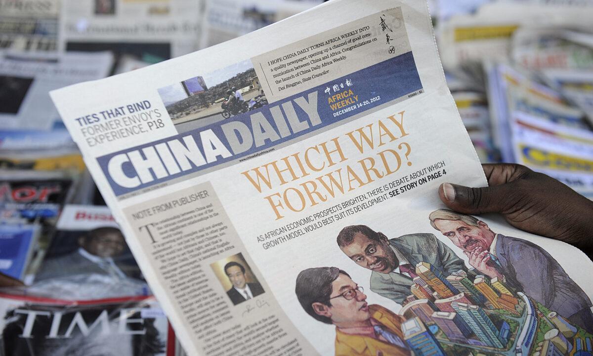A newspaper consumer reads a copy of China Daily's African edition of its daily newspaper in front of a newsstand in the Kenyan capital, on Dec. 14, 2012. (Tony Karumba/AFP via Getty Images)