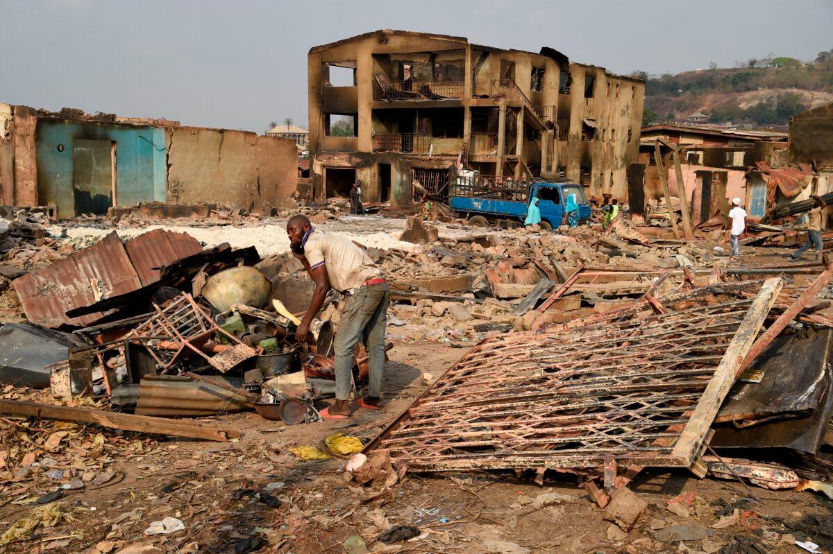 A man tries to salvage valuables from burned shops after deadly ethnic clashes between the northern Fulani and southern Yoruba traders at Shasha Market in Ibadan, Nigeria, on Feb. 15, 2021. (Pius Utomi Ekpei/AFP via Getty Images)