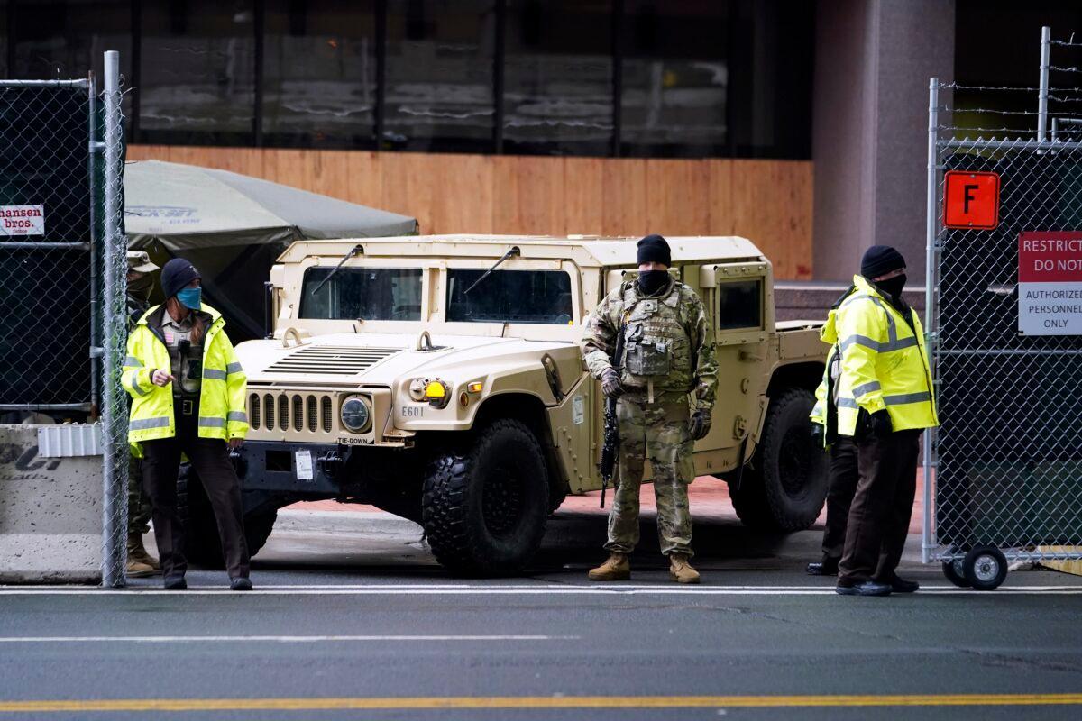 A National Guard soldier, center, stands guard with deputies at the restricted vehicle entrance of the Hennepin County Government Center in Minneapolis, Minn., on April 8, 2021. (Jim Mone/AP Photo)