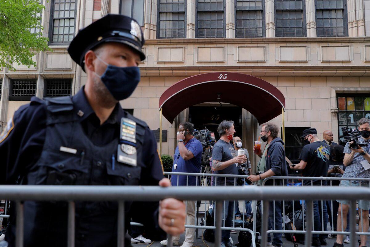 An officer from the New York Police Department places barricades outside the apartment building of Former New York City Mayor Rudy Giuliani, personal attorney to former President Donald Trump, in Manhattan, New York City on April 28, 2021. (Andrew Kelly/Reuters)
