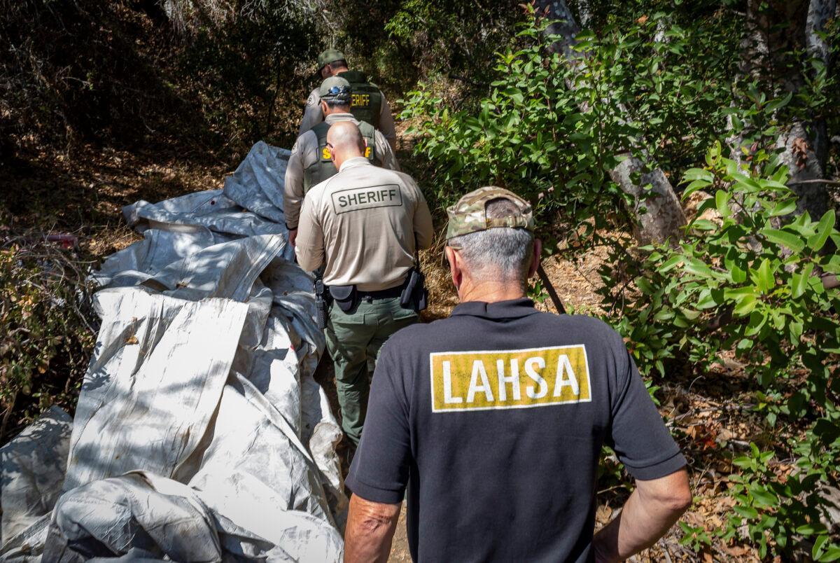 Los Angeles Homeless Services Authority workers join the Los Angeles County Sheriff's Department in assisting homeless individuals in Malibu, Calif., on Sept. 24, 2021. (John Fredricks/The Epoch Times)