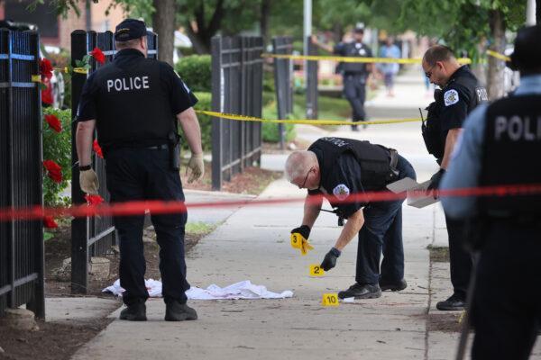 Police investigate a crime scene where three people were shot at the Wentworth Gardens housing complex in the Bridgeport neighborhood in Chicago, Ill., on June 23, 2021. A 24-year-old man died from injuries he suffered in the shooting and two others, a 22-year-old male and a 25-year-old male, were seriously wounded. (Scott Olson/Getty Images)