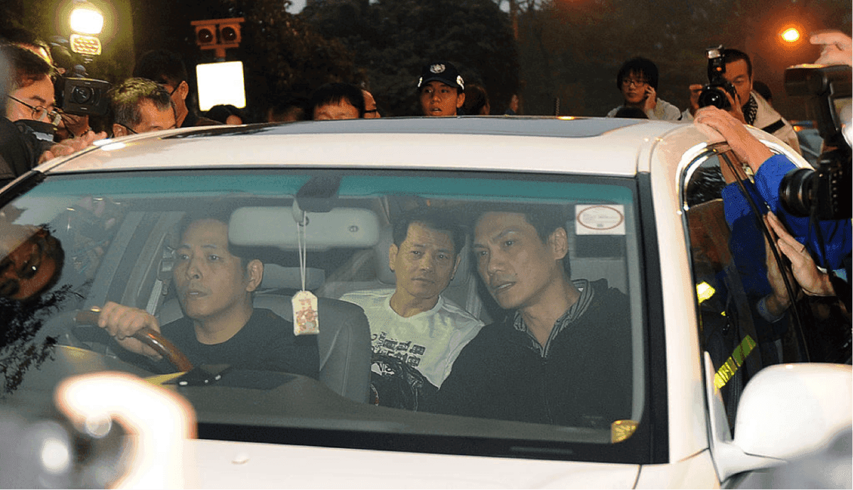 Media surround the car as Wan Kuok-koi (C) is driven away from the Macau prison by two unidentified men on Dec. 1, 2012. (Laurent Fievet/AFP via Getty Images)