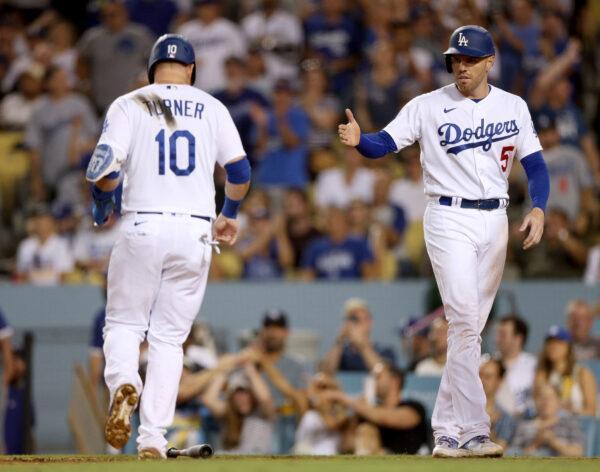 Freddie Freeman (5) and Justin Turner (10) of the Los Angeles Dodgers celebrates their runs from a Joey Gallo #12 double, to take an 8–2 lead over the Milwaukee Brewers, during the fourth inning at Dodger Stadium in Los Angeles, on August 24, 2022. (Harry How/Getty Images)