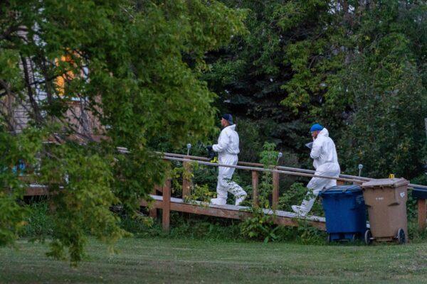 Investigators with protective equipment enter a house in a crime scene in Weldon, Sask., on Sept. 4, 2022. (The Canadian Press/Heywood Yu)