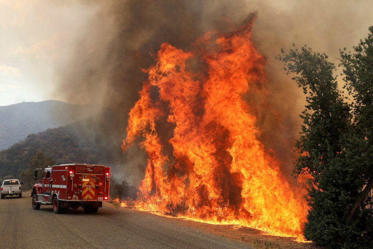 Flames grow next to a fire engine as the Fairview Fire burns near Hemet, Calif., on Sept. 7, 2022. (David Swanson/Reuters)