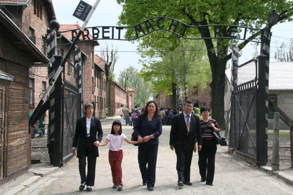 The Chinese panelists at the "Never Again: Appeal to the World" forum on organ harvesting death camps in China walk through the infamous "Work Shall Set You Free" gate at the Auschwitz-Birkenau Memorial and Museum, on May 9, 2006. (Jan Jekielek/The Epoch Times)