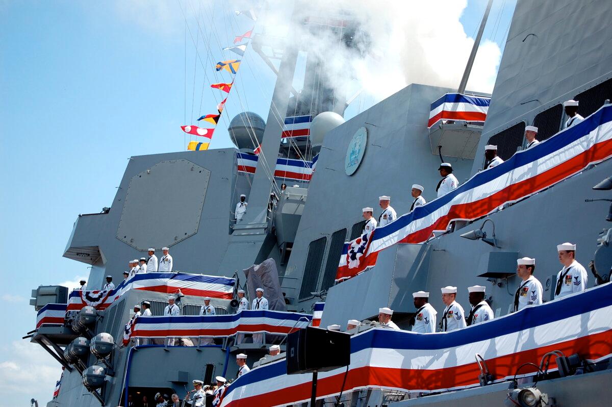 SHIP COMES ALIVE: Following time-honored Navy tradition, when a ship is commissioned, it “comes alive” when the flag is raised, the crew runs on board, and the cannons are fired. (Mary Silver/The Epoch Times)