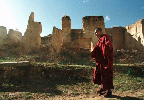 A Tibetan monk walks past ruins at the Gedan Songzan Monastery at Zhongdian, in China's Yunnan Province, on April 23, 1998. Much of the 300 year-old monastery was destroyed by radical communists during China's Cultural Revolution, but is now being rebuilt. (AP Photo/Greg Baker)