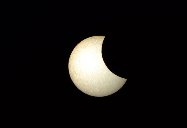 A focused image onto a white background through a telescope shows the moon crossing in front of the Sun as seen from the Sydney Observatory on May 10, 2013. (Saeed Khan/AFP/Getty Images)