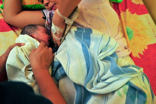 A newborn baby is prepped and handed to the mother moments after delivery inside a birthing room on May 10, 2013. (Veejay Villafranca/Getty Images)
