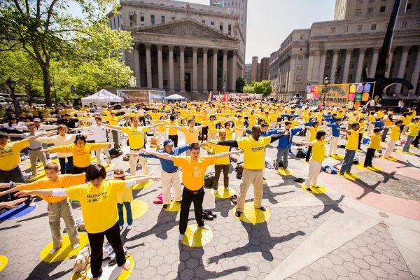 Falun Gong practitioners perform "Buddha Showing a Thousand Hands," the first of the Falun Gong standing exercises, at Foley Square in New York on May 12. They are celebrating 21 years since the ancient meditation discipline was introduced to the general public in China by Mr. Li Hongzhi. In subsequent years, May 13 has come to be known as World Falun Dafa Day. (Edward Dai/The Epoch Times)