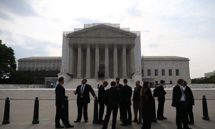 People stand in front of the U.S. Supreme Court building on June 17 in Washington. (Mark Wilson/Getty Images)