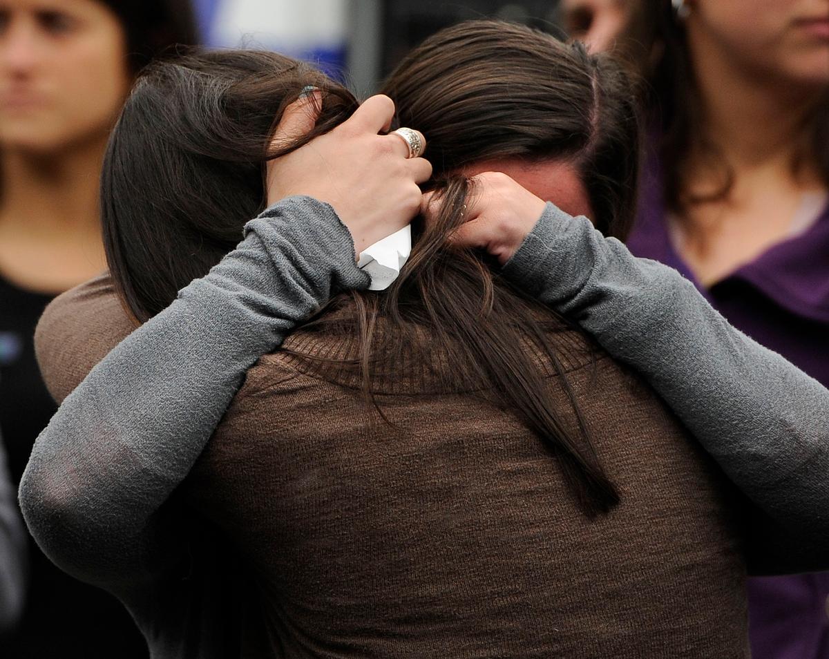 Carlee Soto, front, and Jillian Soto, sisters of slain teacher Victoria Soto, embrace during a ceremony on the six-month anniversary honoring the 20 children and six adults gunned down at Sandy Hook Elementary School on Dec. 14, 2012 in Newtown, Conn. (AP Photo/Jessica Hill)