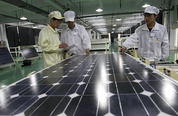 Chinese workers examine solar panels at a manufacturer of photovoltaic products in Huaibei in China's Anhui Province, on March 21, 2012. (AP Photo/File)