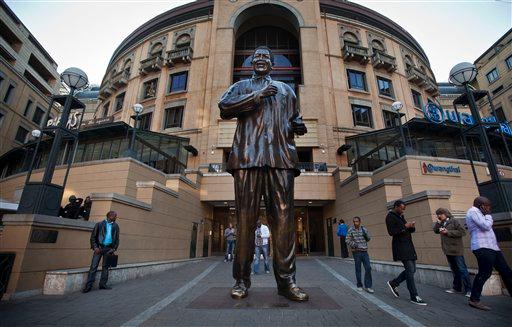 Visitors walk past a statue of Nelson Mandela in Nelson Mandela Square at the Sandton City shopping center in Johannesburg in 2013. (Ben Curtis/AP Photo)