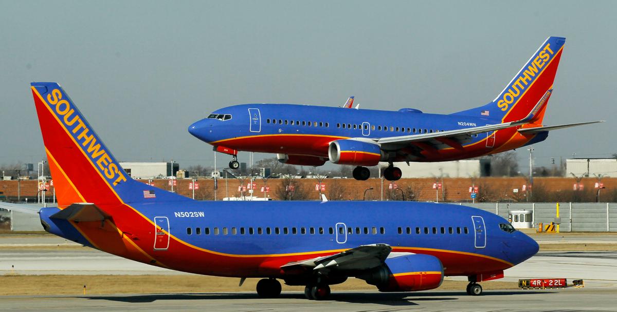 A Southwest Airlines Boeing 737 waits to take off at Chicago's Midway Airport as another plane lands, in this Feb. 9, 2012, file photo.  (AP Photo/Charles Rex Arbogast)