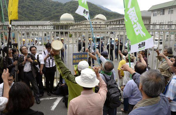 Protesters at the gate of the Takahama nuclear power station after a freighter carrying MOX, a mixture of uranium and plutonium oxide, arrived in Fukui prefecture, Japan, in 2013. (AP Photo/Kyodo News)