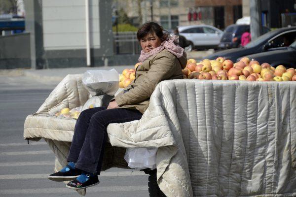 A street vendor in Beijing sits on a trailer filled with apples on April 14, 2013. Such vendors are often harassed or beaten by Chengguans (urban management staff), thugs employed by city governments to enforce municipal regulations. (Wang Zhao/AFP/Getty Images)