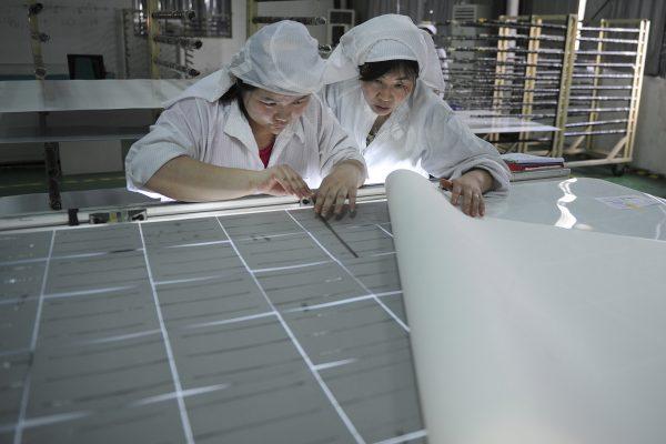 Workers assemble solar panels at a factory in Hefei, Anhui Province, China, on July 27, 2013. (AP Photo)