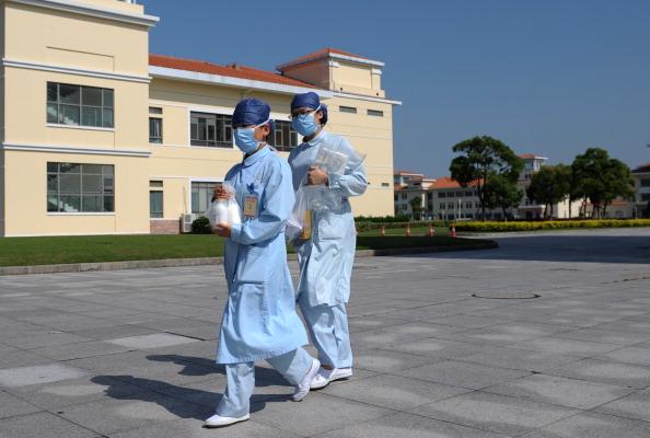 In this photo taken on May 14, 2013, two nurses walk in front of building A3 at an isolation hospital in southwest Shanghai. (Peter Parks/AFP/Getty Images)