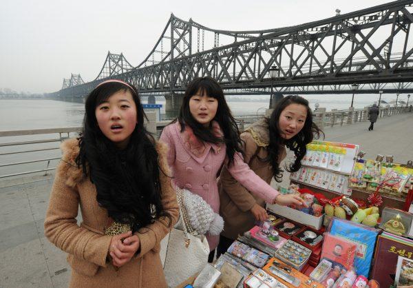 Chinese tourists buy North Korean souvenirs beside the Yalu River Bridge leading to North Korea at the Chinese border town of Dandong on December 28, 2011. (Mark Ralston/AFP/Getty Images)