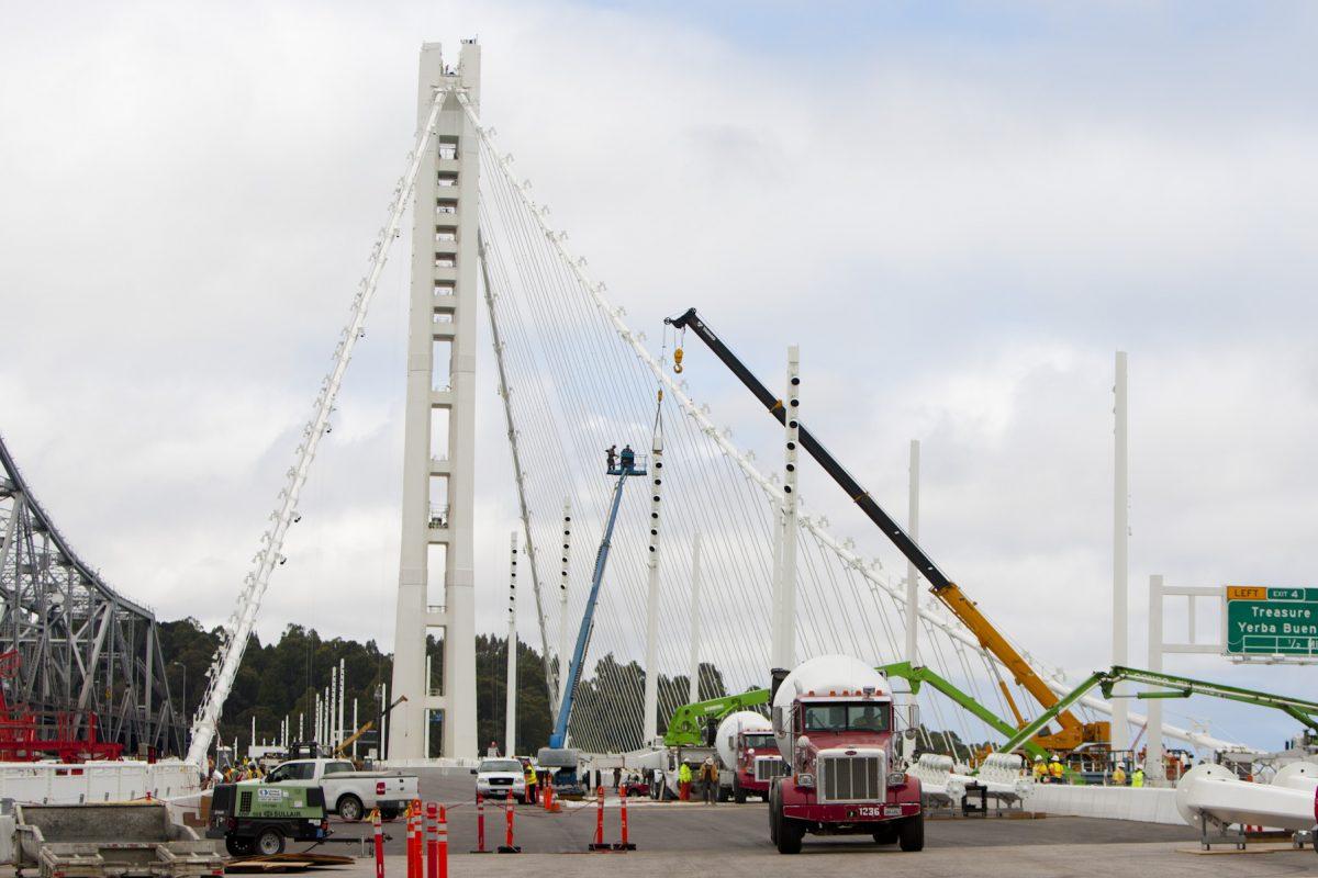 The new eastern span of the San Francisco–Oakland Bay Bridge under construction, with the old span seen in the background (L) in Oakland, Calif., Aug. 8, 2013. (Alex Ma/The Epoch Times)