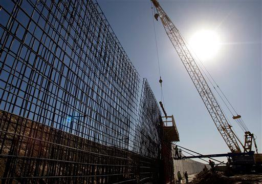 The sun beats down on construction workers constructing the border wall in Granjeno, Texas, on Feb. 4, 2009. (Eric Gay/AP Photo)