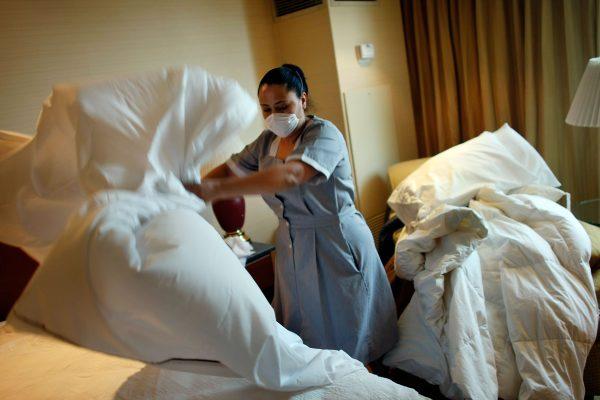 A maid changes sheets in a hotel room. A new do-it-yourself bedbug trap may help keep hotel rooms safer for visitors. (Joe Raedle/Getty Images)