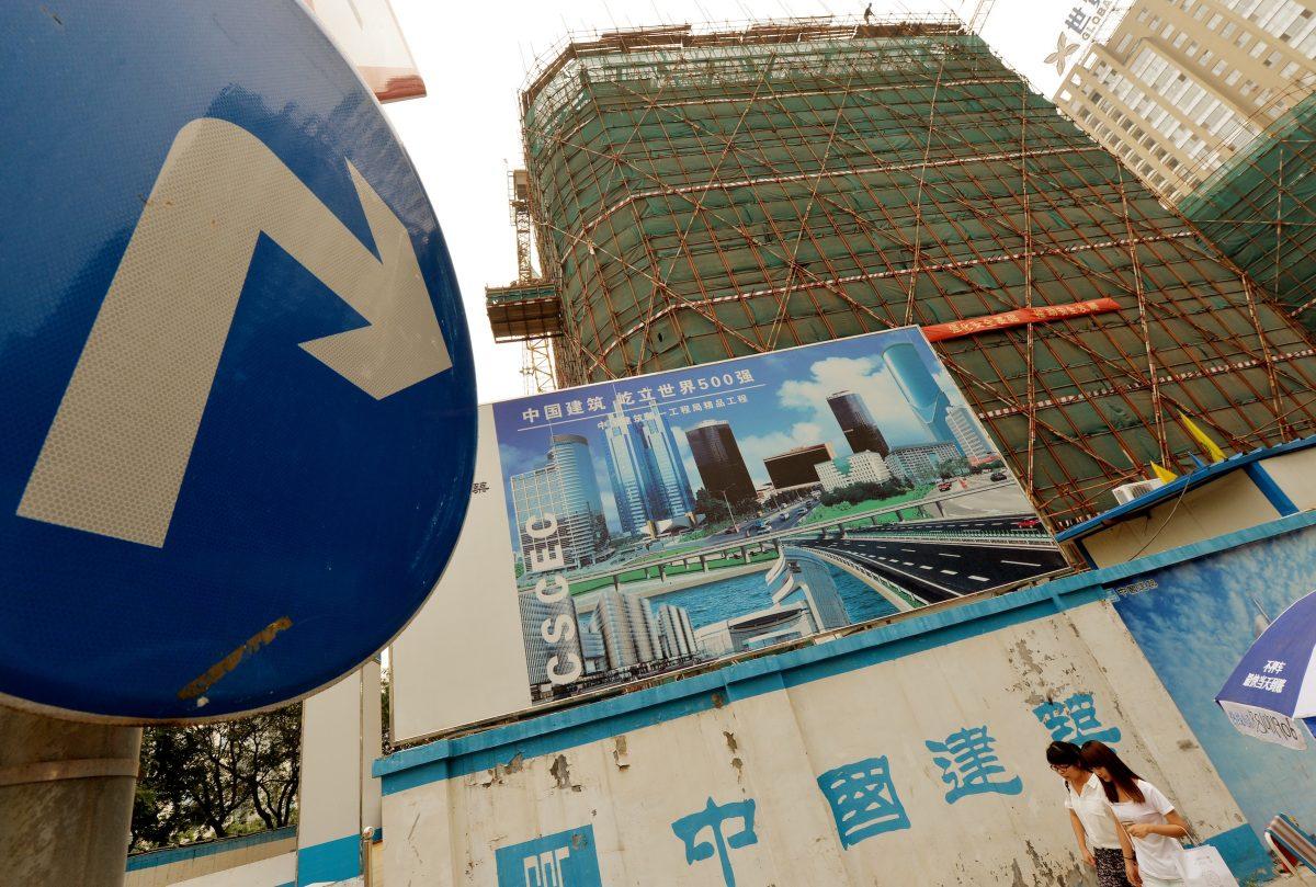 Chinese commuters walk past property development billboards in the Central Business District in Beijing on July 26, 2013. Local governments around China are worried about the investigation into their debt being organized now by central authorities. (Mark Ralston/AFP/Getty Images)