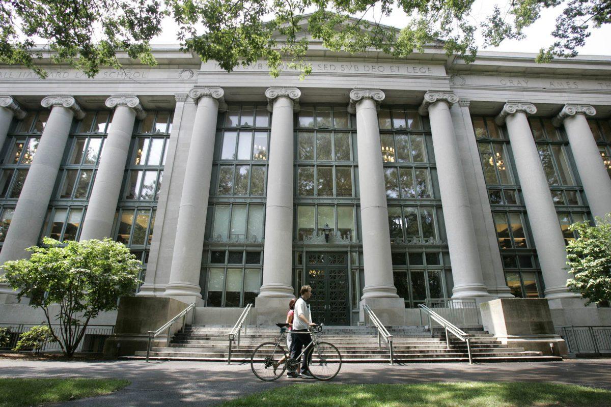 A bicyclist walks by Langdell Hall, the Harvard Law Library, on the campus of the Harvard Law School in Cambridge, Mass., in a file photo. (AP Photo/Charles Krupa)
