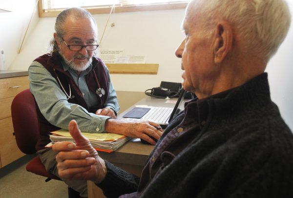 Ronald Pitkin (right) talks with Dr. John Matthew during an office visit in Plainfield, Vt., on June 6, 2013. (Toby Talbot/AP)