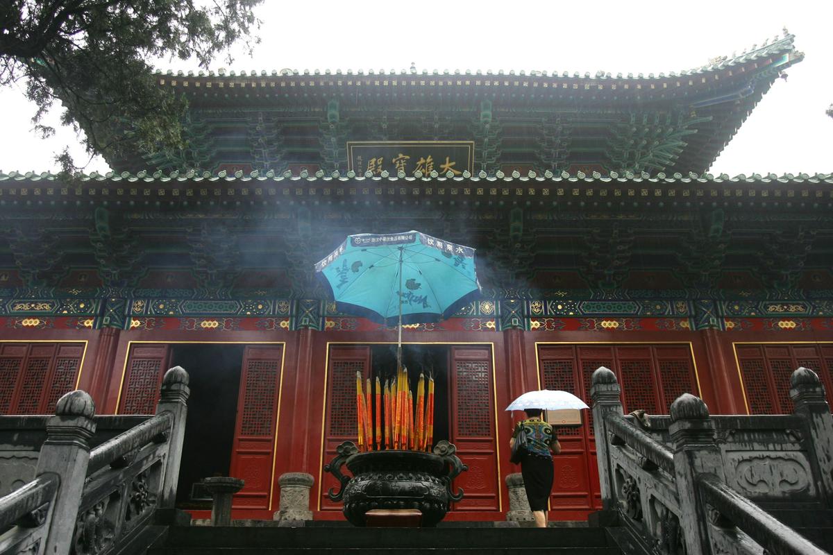 A tourist walks to a shrine at Shaolin Temple on Songshan Mountain, in Henan Province, on Aug. 25, 2006. The Temple was built in AD 495 and is considered the birthplace of Shaolin Kung Fu. (China Photos/Getty Images)