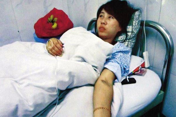 Feng Jianmei lies on a hospital bed after a forced abortion during her seventh month of pregnancy, in Northwest China's Shaanxi province on June 4, 2012. Photos of her with her aborted baby next to her on the bed went viral in China and provoked fury at the regime's one-child system and the forced abortions that accompany it. (bbs.hsw.cn)
