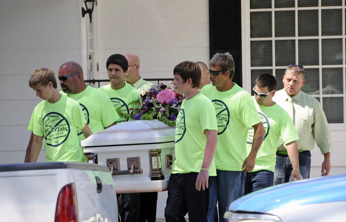 Pallbearers wearing anti-bullying T-shirts carry the casket of bullying victim Rebecca Sedwick, 12, to a waiting hearse as they exit the Whidden-McLean Funeral Home in Bartow, Fla., in November 2013. (Brian Blanco/AP Photo)