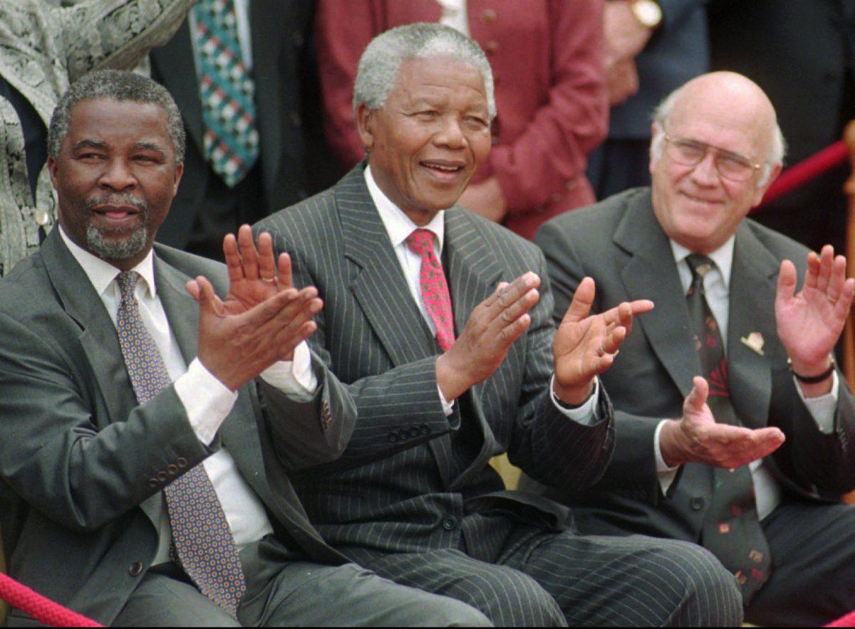 South African President Nelson Mandela (C) applauds along with his two deputy presidents, Thabo Mbeki (L) and F.W. de Klerk (R) after a new constitution was approved by the Constitutional Assembly in Cape Town, South Africa, on May 8, 1996. (Leon Muller/AP Photo)
