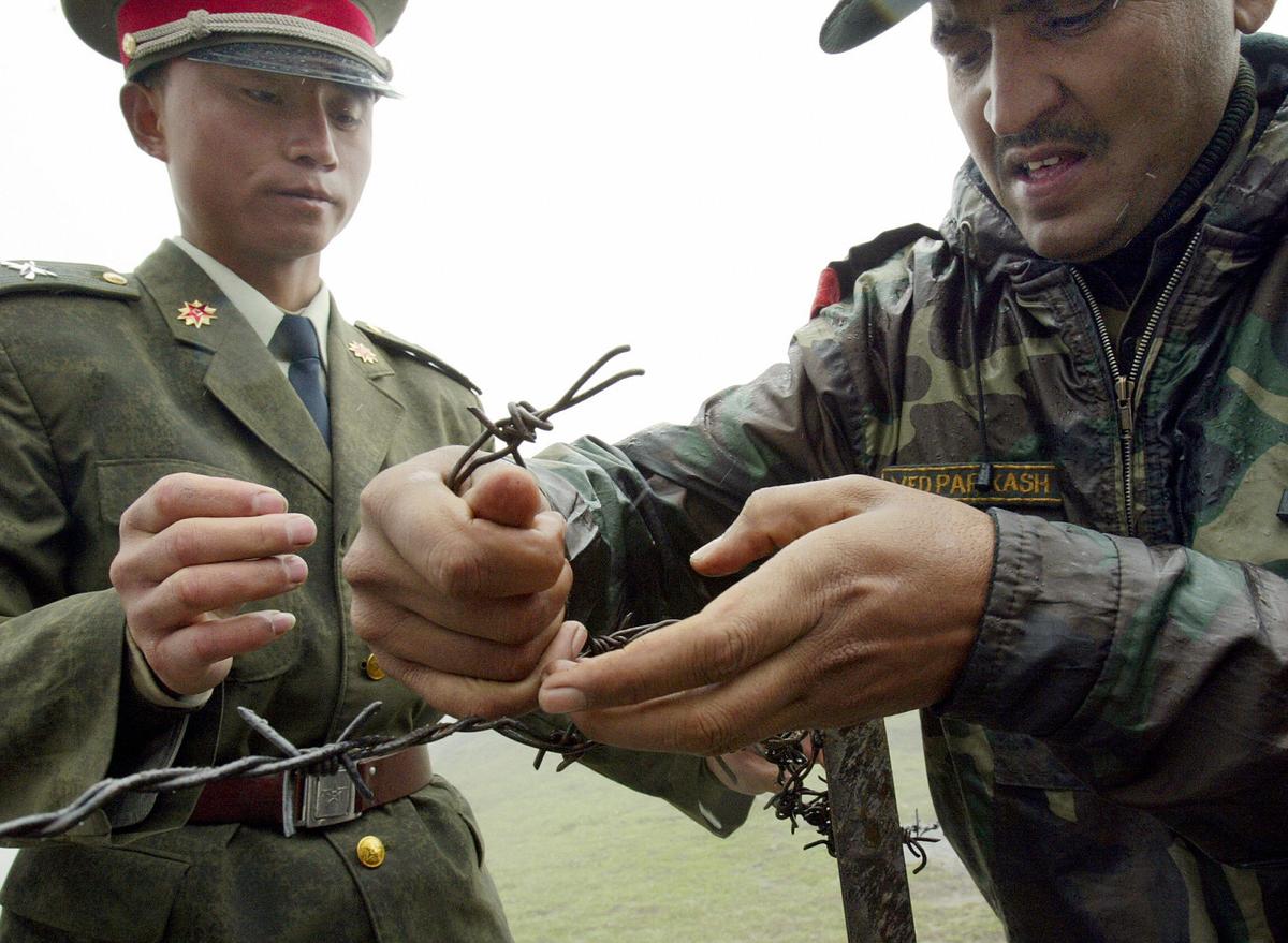 A PLA Soldier and Indian Army Officer mend fences in the disputed region on 2013. (Deshakalyan Chowdhary/AFP/Getty Images)