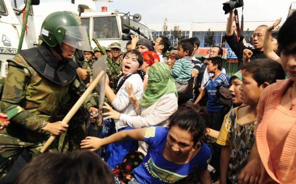 Chinese riot police battle ethnic Uyghur women protesting land confiscation, lease termination, and the detention of male villagers in Urumqi in China's far west Xinjiang province, on July 7, 2009. (Peter Parks/AFP/Getty Images)