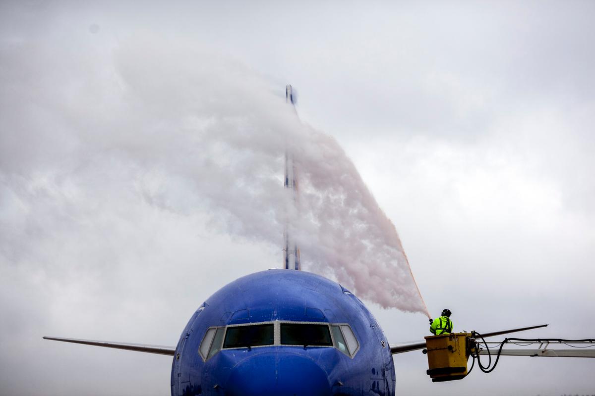 A worker from Wilson Air Center de-ices a Southwest Airlines plane before it lifts off for Orlando, Fla., on Dec. 6, 2013, at the Memphis International Airport in Memphis, Tenn.  (AP Photo/The Commercial Appeal, Mark Weber)