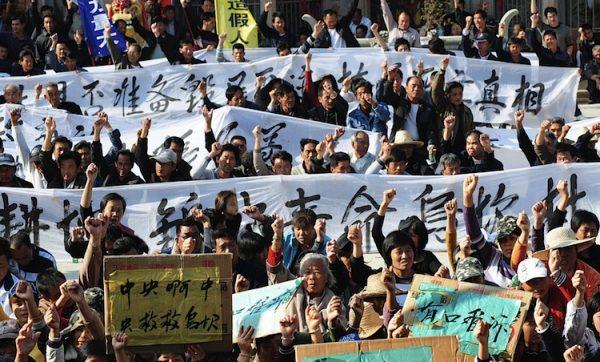 Villagers hold banners during a protest rally in Wukan, Guangdong Province, on Dec. 19, 2011. They demand central authorities to take action over illegal land grabs and the death of a local leader in custody. (STR/AFP/Getty Images)